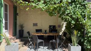 a table and chairs on a patio with plants at Maison HELIOS - Eguisheim in Eguisheim