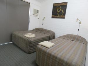twee poeven in een kamer met twee bedden bij Emerald Gardens Motel & Apartments in Emerald