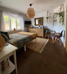 a bedroom with a bed and a table and a chair at The Bloom-Room in Stratford-upon-Avon