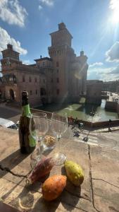 a table with two wine glasses and a castle at Residence Largo Castello in Ferrara
