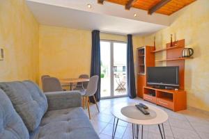 a living room with a couch and a tv and a table at Apartman Mara in Pomer