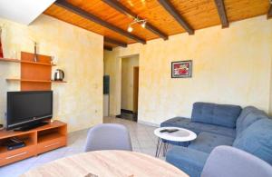 a living room with a blue couch and a tv at Apartman Mara in Pomer