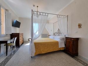 a bedroom with a canopy bed and a table at Albergo Il Marzocco - Hotel dal 1860 in Montepulciano