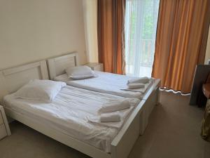 a bedroom with a bed with white sheets and pillows at LizAna in Shekhvetili