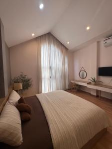 a bedroom with a large bed with a large window at Mango Home & Apartment in Danang