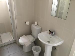 a white bathroom with a toilet and a sink at Mandali Court in Ayia Napa