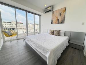 a bedroom with a bed and a large window at StayX Sky Garden in Ba Ria