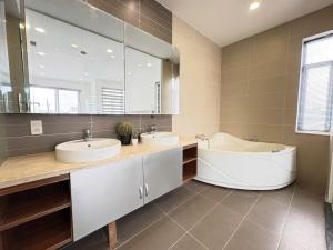 a bathroom with two sinks and a tub and a large mirror at StayX Sky Garden in Ba Ria +26 photos