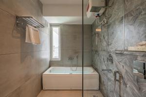 a bathroom with a bath tub and a shower at Perfectstayz AIIMS near Aiims Hospital in Rishīkesh