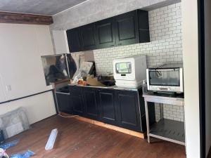 a kitchen with black cabinets and a white microwave at RB hotel in Aizuwakamatsu