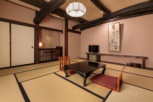 a living room with a table and chairs in it at Yumoto Choza in Takayama