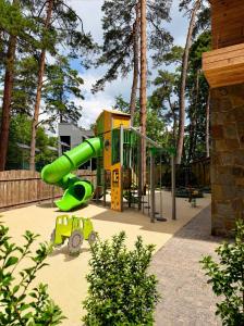 a playground with a green slide in a park at Shpatser hotel in Briukhovychi