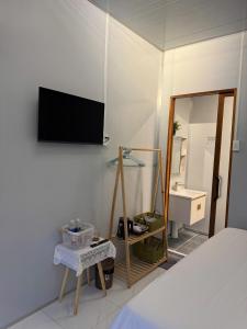 a bedroom with a bed and a tv on the wall at Bụi Tre Homestay in Ben Tre