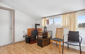 a living room with a chair and a stove at 2 Bedroom Nice Apartment In Ringkøbing in Ringkøbing