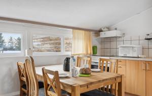 a kitchen with a wooden table with chairs and a microwave at 2 Bedroom Nice Apartment In Ringkøbing in Ringkøbing