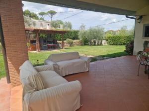a patio with two white couches and a table at Linda's Retreat in Fiano Romano
