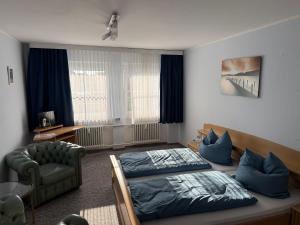a bedroom with a bed and a chair in it at Gästehaus am Binnensee in Heiligenhafen