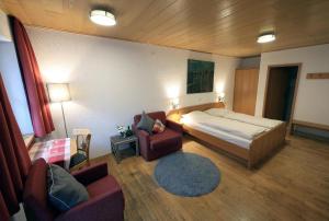 a bedroom with a bed and a couch and a chair at Gästehaus am Westtor in Prichsenstadt