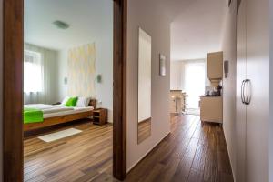 a bedroom with a bed and a room with a mirror at Aqualiget-Apartmanház E-Car plug-in point Szeged in Szeged