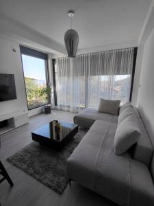 a living room with a couch and a large window at B&L Apartmani in Sutomore