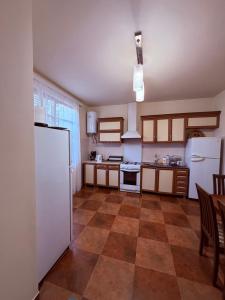 a kitchen with white appliances and a tile floor at Tinano in Kuchkisabano