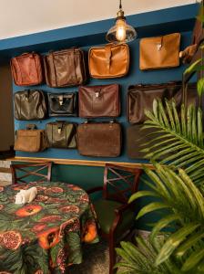 a bunch of bags hanging on a wall with a table at Chemodann Kazbegi in Kazbegi