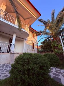 a house with a palm tree in front of it at Tinano in Kuchkisabano