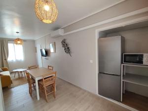 a kitchen and dining room with a table and a refrigerator at le maquis in Sisco