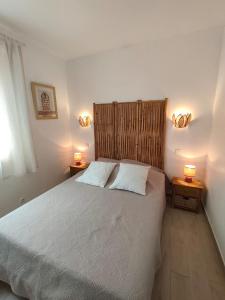 a bedroom with a bed with two lamps on two tables at le maquis in Sisco