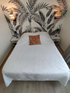 a bedroom with a white bed with two night stands at le maquis in Sisco