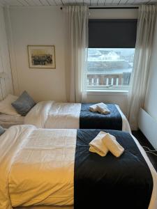 two beds in a hotel room with a window at Astra Whale - Waterfront Boutique Hostel in Lofoten in Kabelvåg +23 photos
