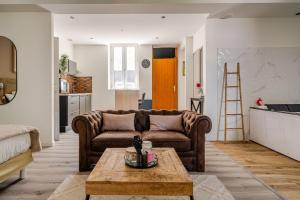 a living room with a couch and a table at L'Eden Spa - Jacuzzi - Saint-Etienne in Saint-Étienne