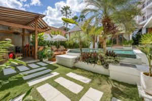 a backyard with a swimming pool and a house at Noho Stay Bali in Uluwatu
