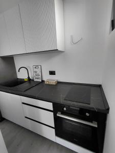 a kitchen with a black counter top and a sink at B&L Apartmani in Sutomore +7 photos