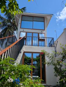 a house with glass doors and a balcony at Bahari View in Jambiani