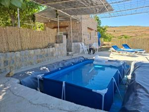 a swimming pool in a backyard with a blue pool at Beit El Jabal in Al Mudayrij