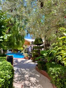 a garden with a swimming pool and trees and bushes at Mitos Apartments in Marmaris