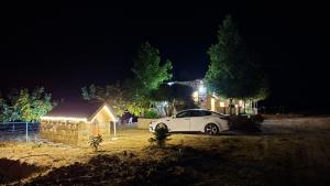 a white car parked in front of a house at night at Beit El Jabal in Al Mudayrij
