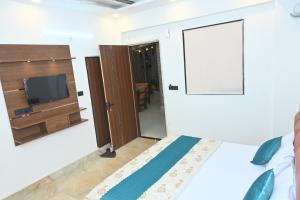 a bedroom with a bed and a tv on a wall at Hotel Shankara Inn in Ayodhya +26 photos
