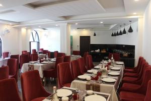 a dining room with tables and red chairs at Hotel Yadu Vilas in Phata