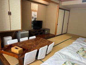 a room with a table and chairs and a tv at RB hotel in Aizuwakamatsu