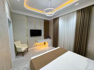 a bedroom with a bed and a desk and a tv at ASR Plaza in Jizzax