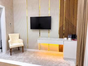 a living room with a tv on a wall with a chair at ASR Plaza in Jizzax