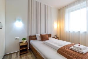 Un pat sau paturi într-o cameră la Aqualiget-Apartmanház