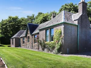 an old stone house with a green lawn at Rose Cottage - Uk52178 in Leven
