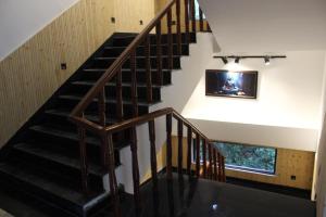 a wooden staircase in a house with a picture on the wall at Hotel Yadu Vilas in Phata
