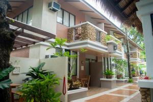 a house with a courtyard with plants in front of it at Katunggan Cove Resort in Nueva Valencia