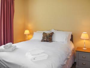 a bedroom with a white bed with towels on it at Rose Cottage - Uk52178 in Leven