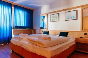 ein Schlafzimmer mit einem großen Bett, auf dem Handtücher liegen in der Unterkunft B&B Chalet Brigitte Hike & Bike in Arabba