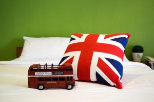 合艾的住宿－บ้านภูมิพันธ์，玩具巴士坐在床上,带枕头